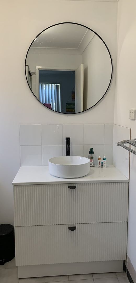 Plumber installing bathroom tapware in a Newcastle home